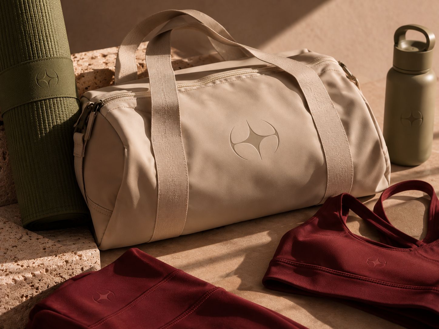 Bolsa de academia areia com símbolo em relevo, tapete de ioga oliva e garrafa ao lado